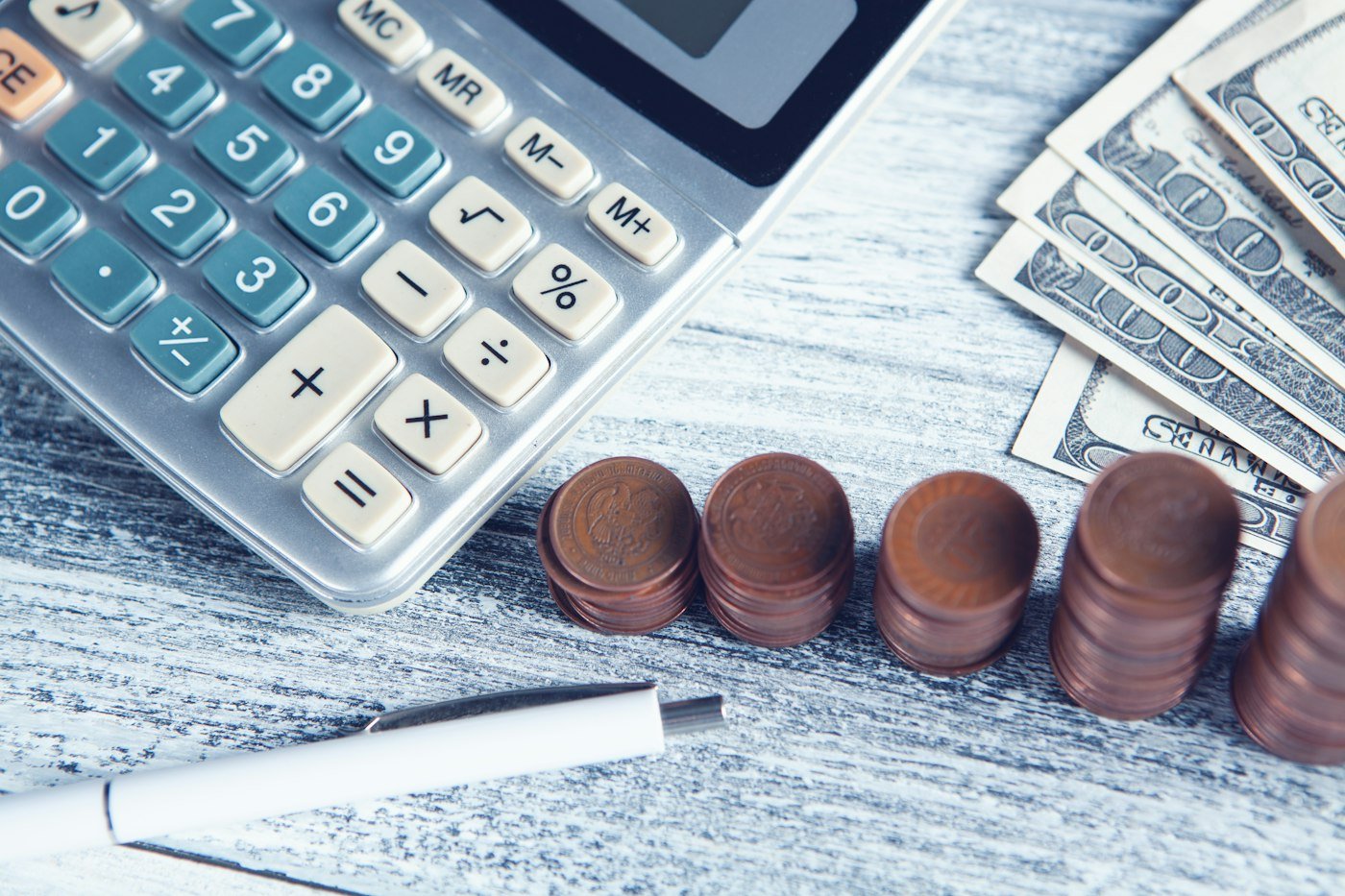 Calculadora, monedas y billetes sobre la mesa
